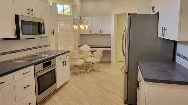 a kitchen with a refrigerator and a stove top oven