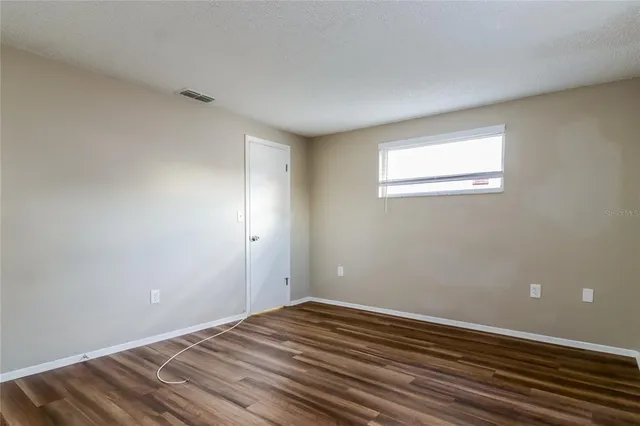 a view of a room with wooden floor and white walls