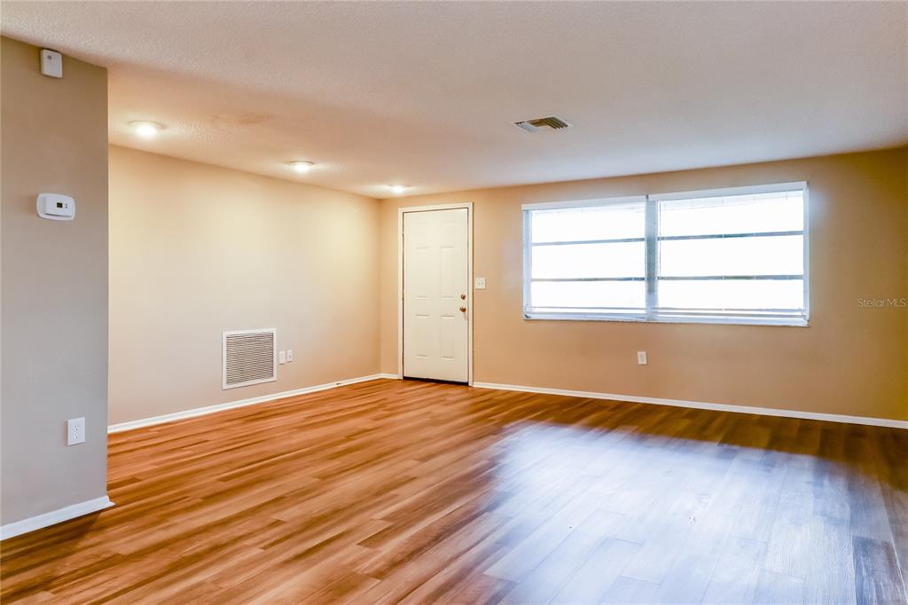 8653 Sabal Way Port Richey, FL 34668 - Photo 2 of 16 an empty room with wooden floor and windows