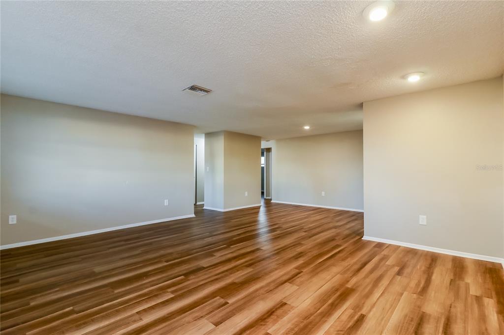 8653 Sabal Way Port Richey, FL 34668 - Photo 3 of 16 a view of an empty room with wooden floor and a window