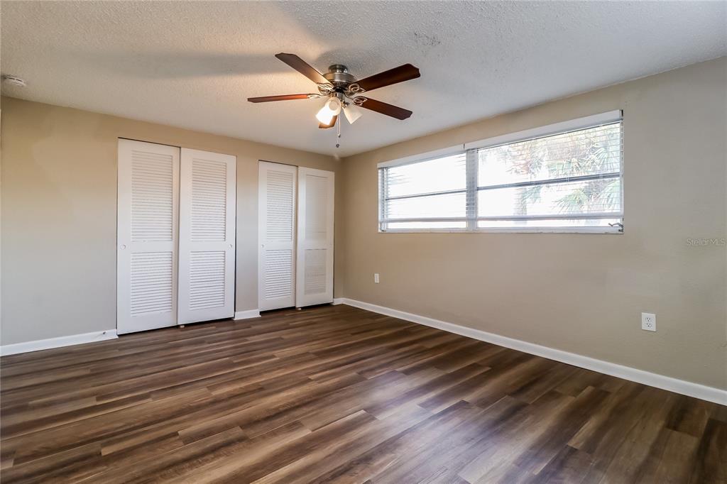 8653 Sabal Way Port Richey, FL 34668 - Photo 7 of 16 a view of an empty room with wooden floor and a window