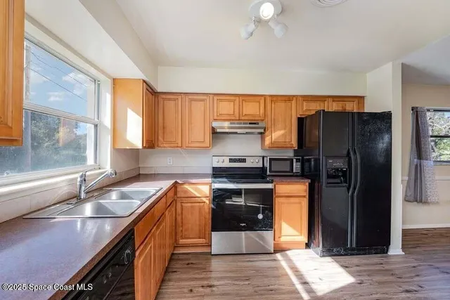 a kitchen with stainless steel appliances granite countertop a refrigerator a sink and a stove