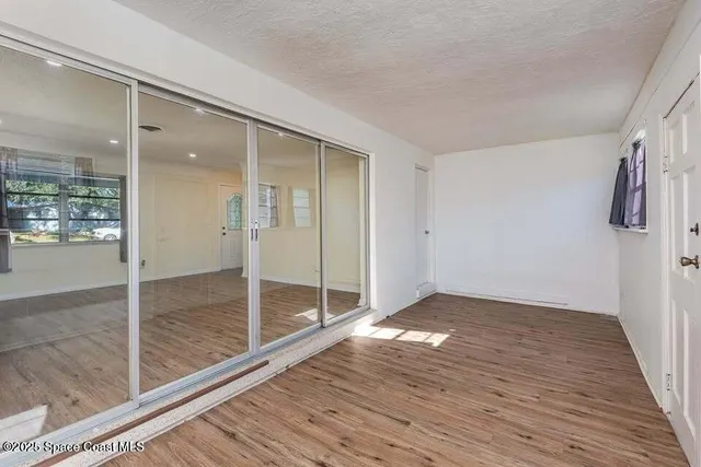 a view of empty room with wooden floor
