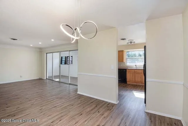 a view of a room with wooden floor and cabinets