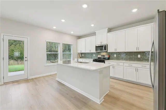 a kitchen with stainless steel appliances granite countertop a stove a sink and a microwave