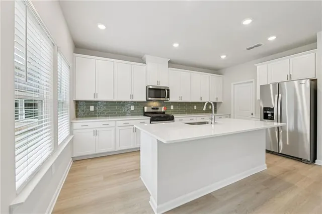 a kitchen with stainless steel appliances a refrigerator stove microwave and sink