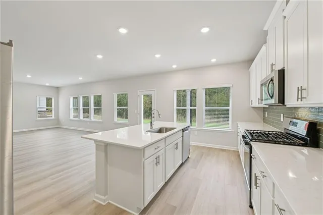 a large white kitchen with sink and windows