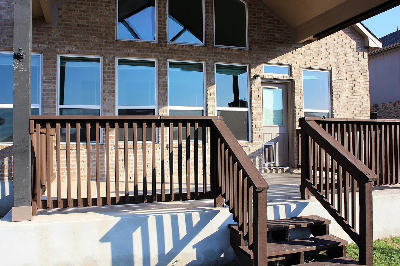 717 Paper Daisy Path Leander, TX 78641 - Photo 3 of 7 A spacious wooden deck provides ample outdoor living space, complementing the brick exterior.