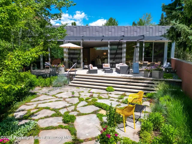 a view of a house with sitting area and a garden