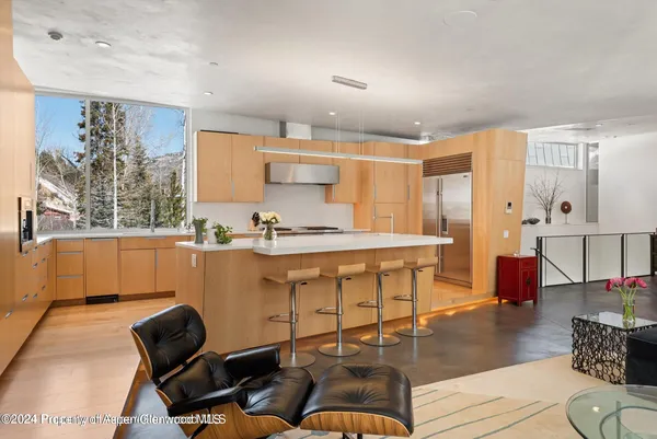 a living room with stainless steel appliances kitchen island granite countertop furniture and a large window