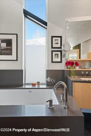 a large bathroom with a tub a sink and a mirror