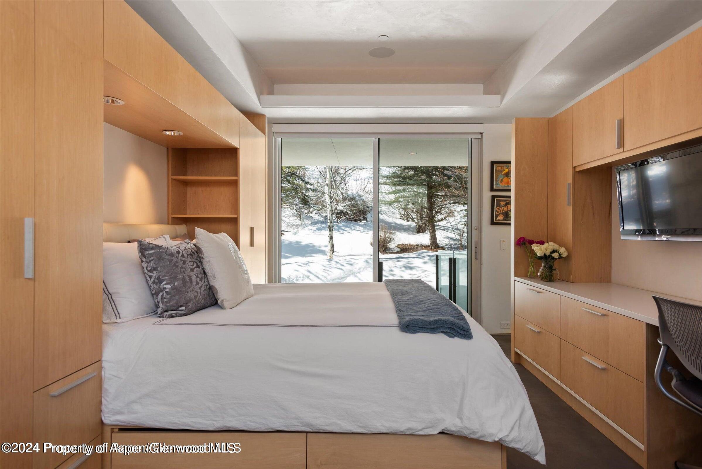 1015 Cemetery Lane Aspen, CO 81611 - Photo 26 of 46 a bedroom with a large bed and a flat tv screen on dresser