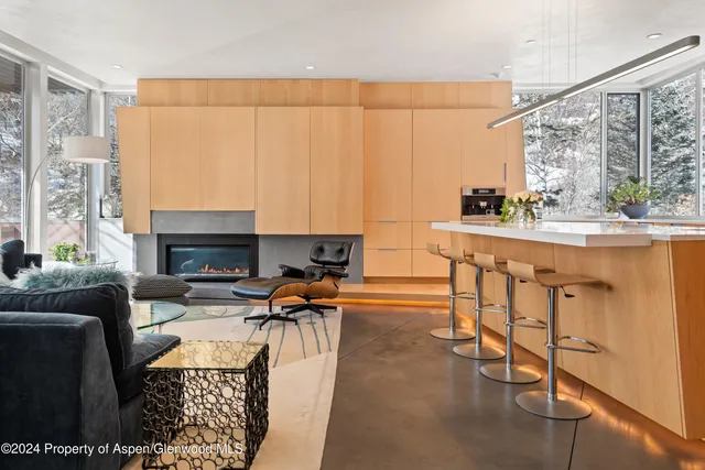 a living room with furniture a fireplace and a floor to ceiling window