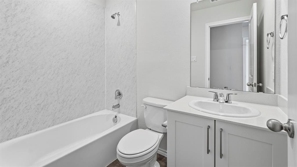 3535 Spring Time Street Forney, TX 75126 - Photo 22 of 23 Bathroom featuring a white bathtub, shower surround, toilet, and vanity with an integrated sink and mirror
