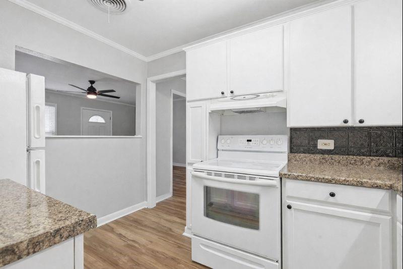 216 4th Street Joshua, TX 76058 - Photo 12 of 40 a kitchen with a stove and white cabinets