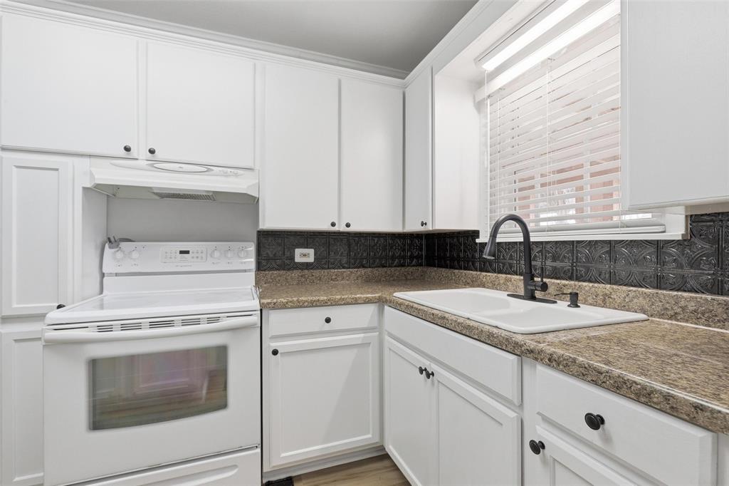 216 4th Street Joshua, TX 76058 - Photo 14 of 40 a kitchen with granite countertop white cabinets and white appliances