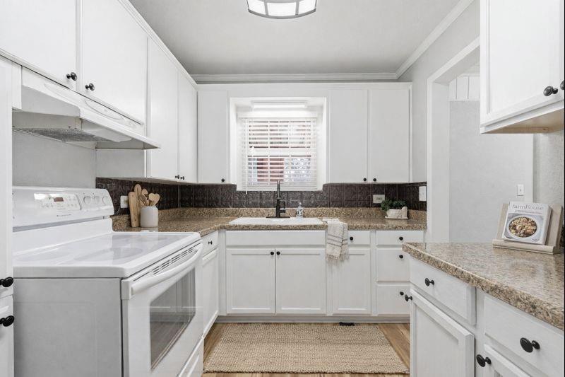 216 4th Street Joshua, TX 76058 - Photo 4 of 40 a kitchen with granite countertop white cabinets sink and white appliances