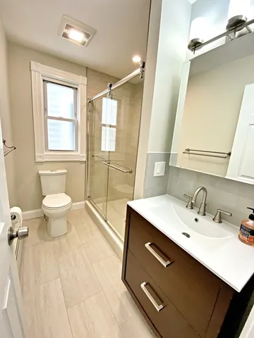 a bathroom with a sink a toilet a mirror and a tub