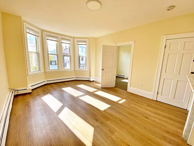 a view of a room with wooden floor and window
