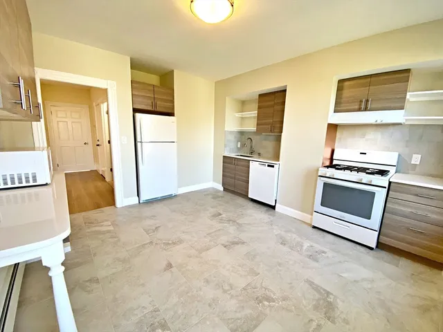 a large white kitchen with stainless steel appliances