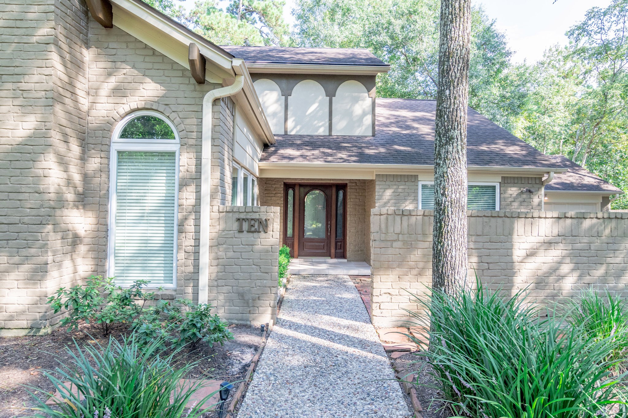10 Coralvine Court Spring, TX 77380 - Photo 5 of 34 Light neutral brick is pleasing and the partial wing wall provides privacy for a courtyard sitting area.