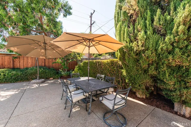 a view of a patio with table and chairs under an umbrella