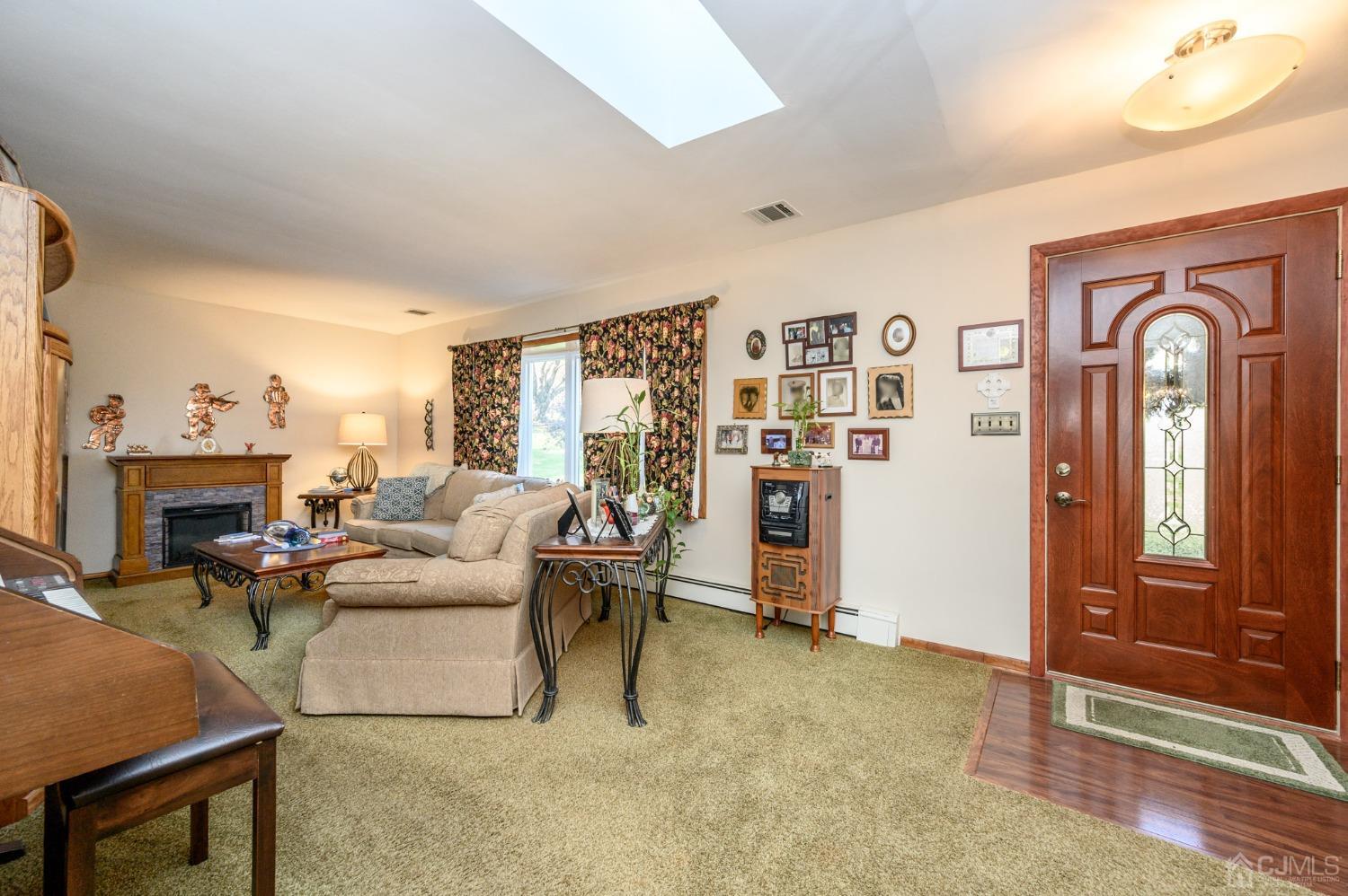 7 Putters Road Succasunna, NJ 07876 - Photo 4 of 40 a living room with furniture a fireplace and a large window