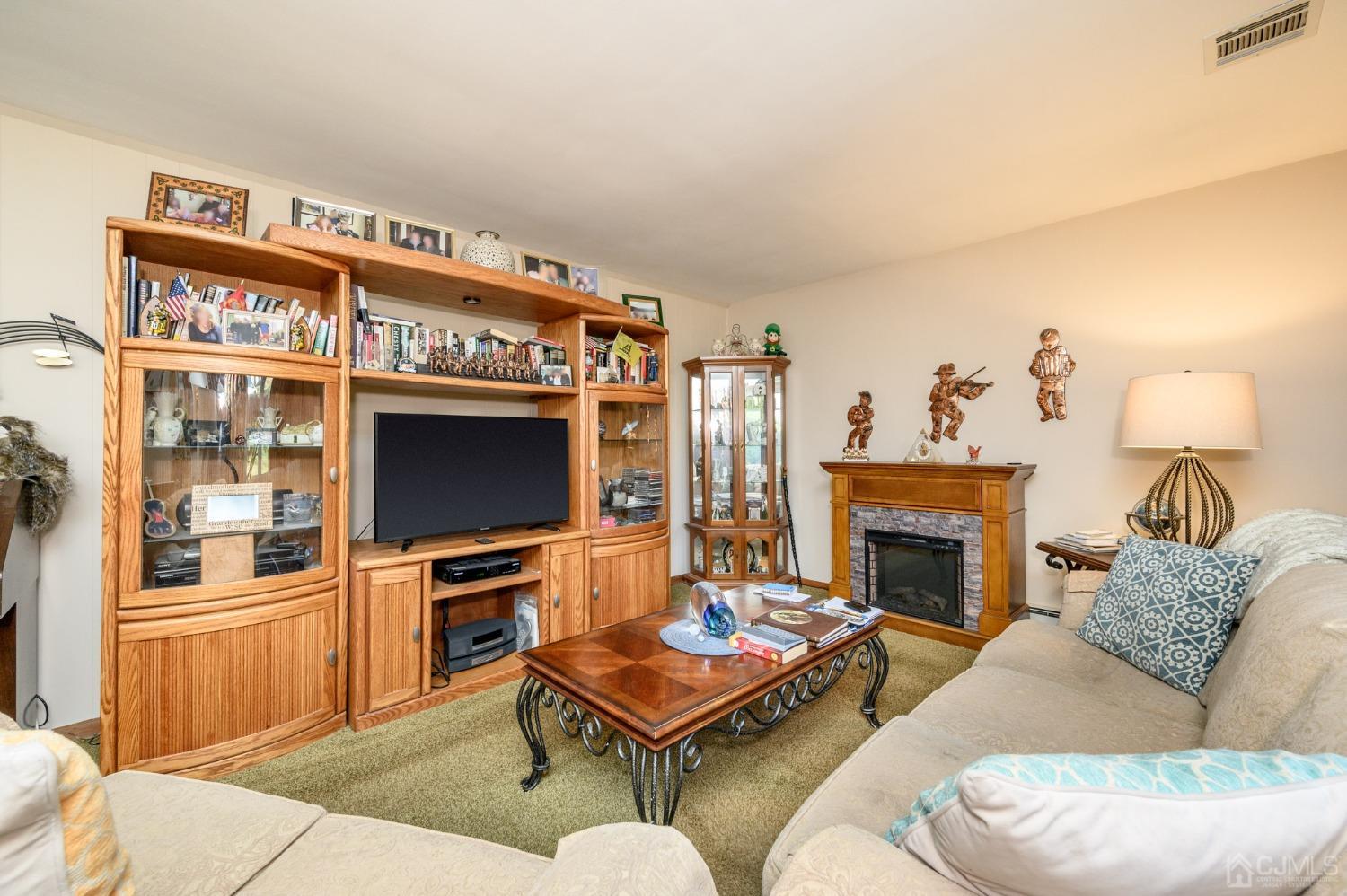 7 Putters Road Succasunna, NJ 07876 - Photo 6 of 40 a living room with furniture a flat screen tv and a fireplace