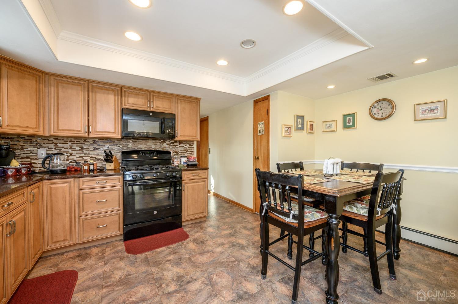 7 Putters Road Succasunna, NJ 07876 - Photo 9 of 40 a kitchen with stainless steel appliances kitchen island granite countertop a dining table chairs and a refrigerator