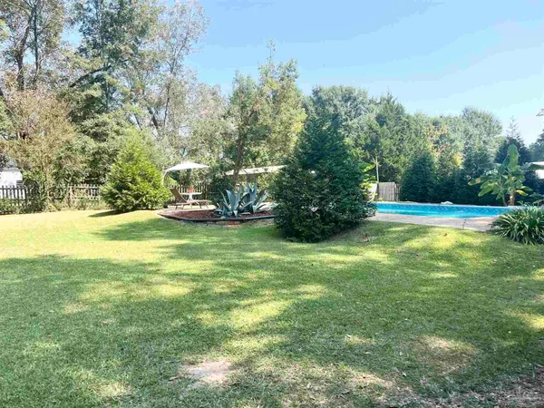 a view of yard with swimming pool and green space