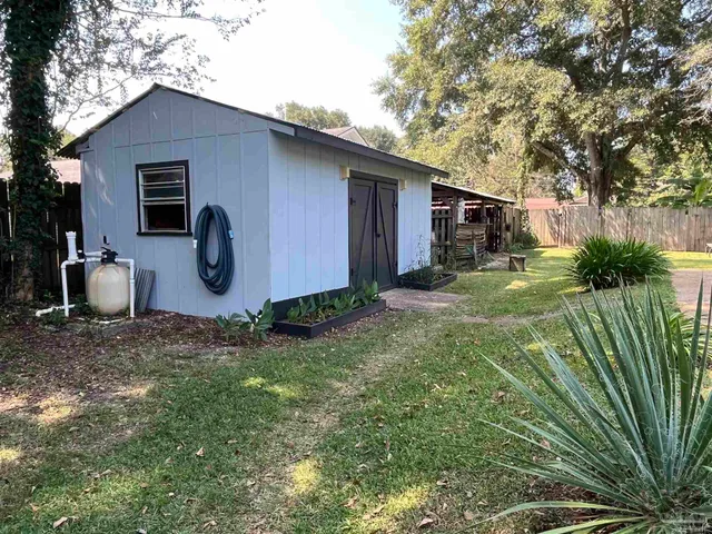 a view of a backyard house with large trees and plants