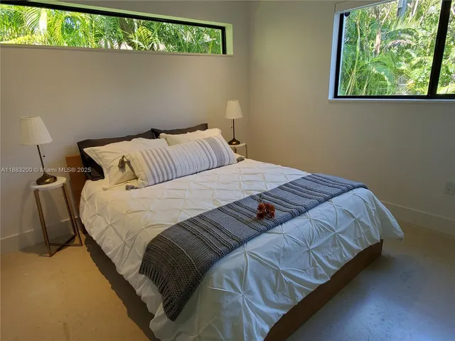 a bedroom with a bed and a flat tv screen on a dresser