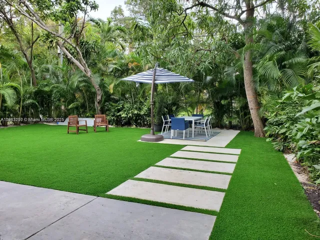 a view of a garden with a bench under an umbrella