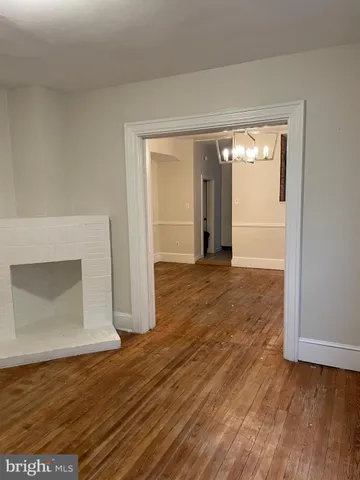 an empty room with wooden floor and fireplace