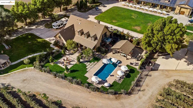 a kitchen with stainless steel appliances granite countertop a stove top oven a dining table and chairs with wooden floor