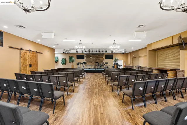 a dining room with stainless steel appliances granite countertop a table chairs and a view of kitchen