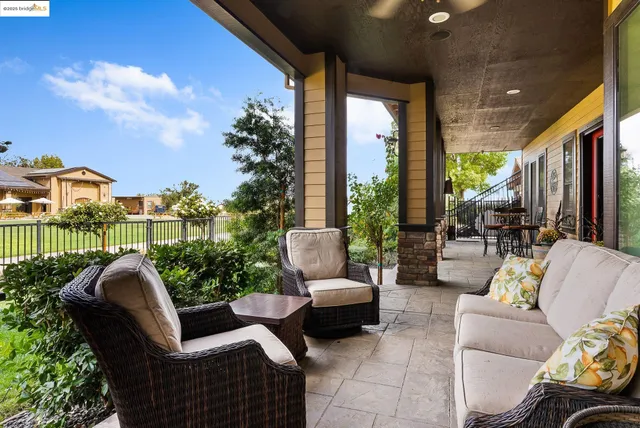 a living room with furniture kitchen view and a large window