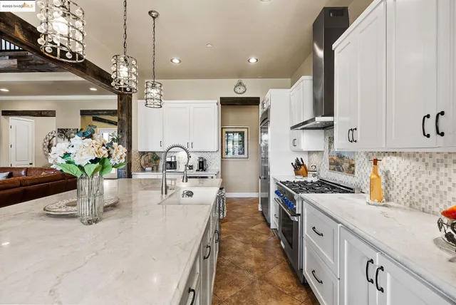 a dining hall with stainless steel appliances granite countertop a sink counter space and living room view