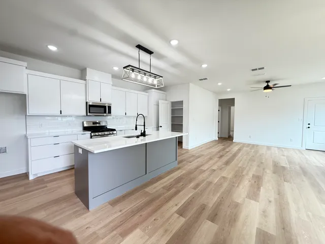 a large kitchen with kitchen island a sink stainless steel appliances and cabinets