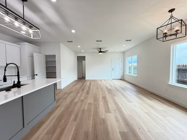 a view of a kitchen with a sink and wooden floor