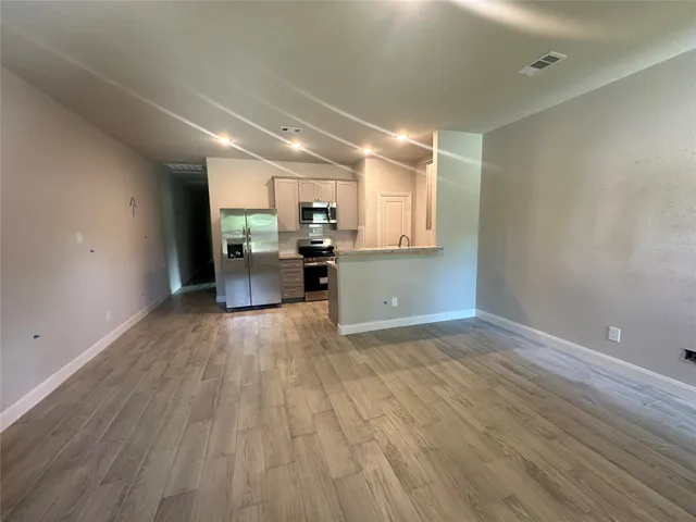 a view of a kitchen with furniture and wooden floor