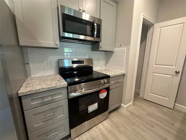 a kitchen with stainless steel appliances granite countertop a stove and a microwave