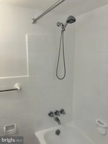 a bathroom with a bath tub with a shower