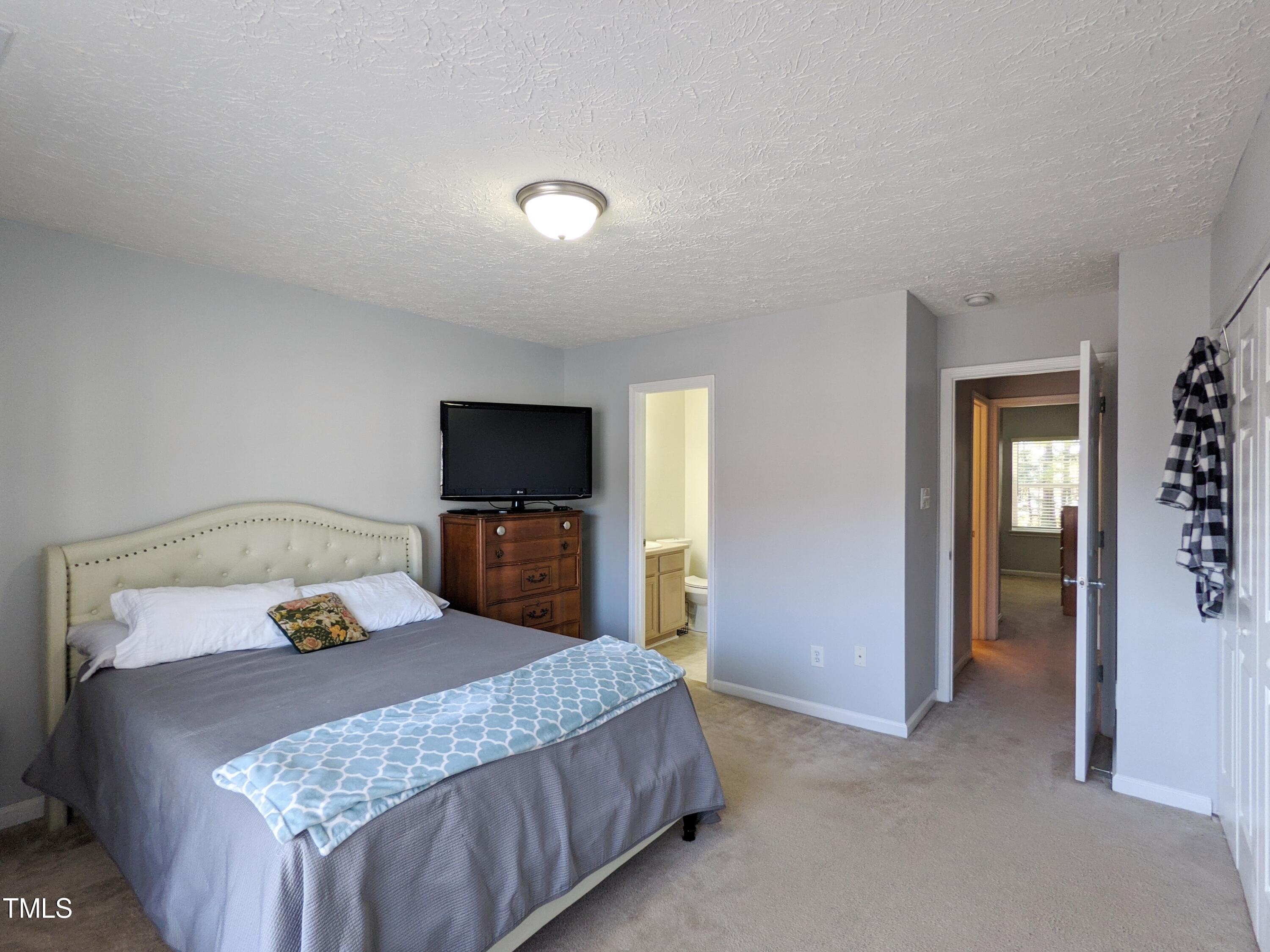 424 St John Drive Durham, NC 27703 - Photo 9 of 14 a bedroom with a bed and a flat screen tv