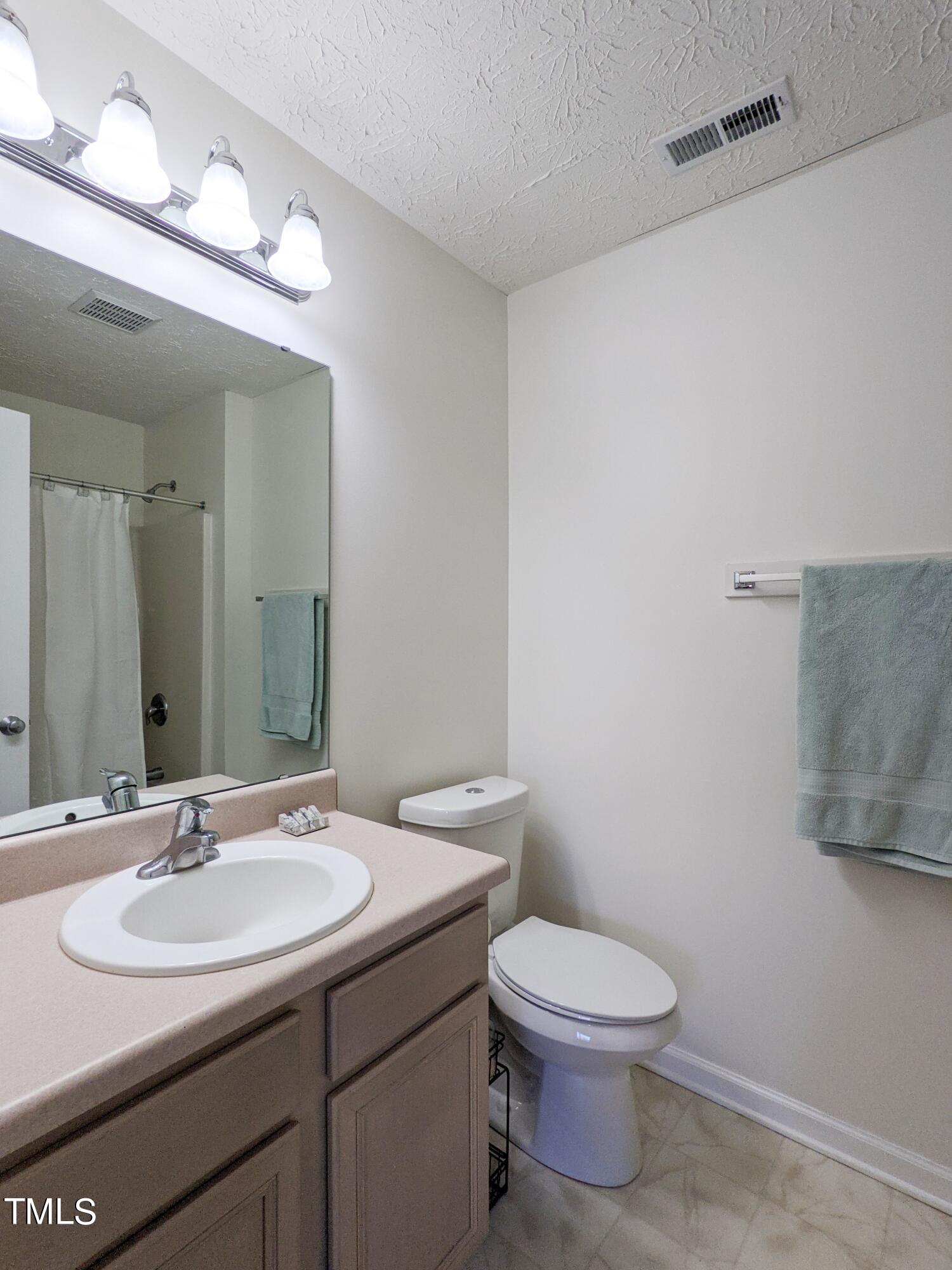 424 St John Drive Durham, NC 27703 - Photo 10 of 14 a bathroom with a toilet a sink and mirror