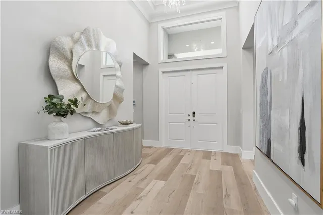 a dining room with wooden floor a chandelier a wooden table and chairs