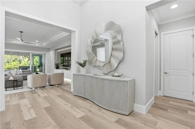 a view of a dining room with furniture a potted plant and a chandelier