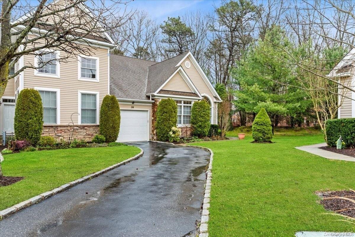 a front view of a house with a yard and trees