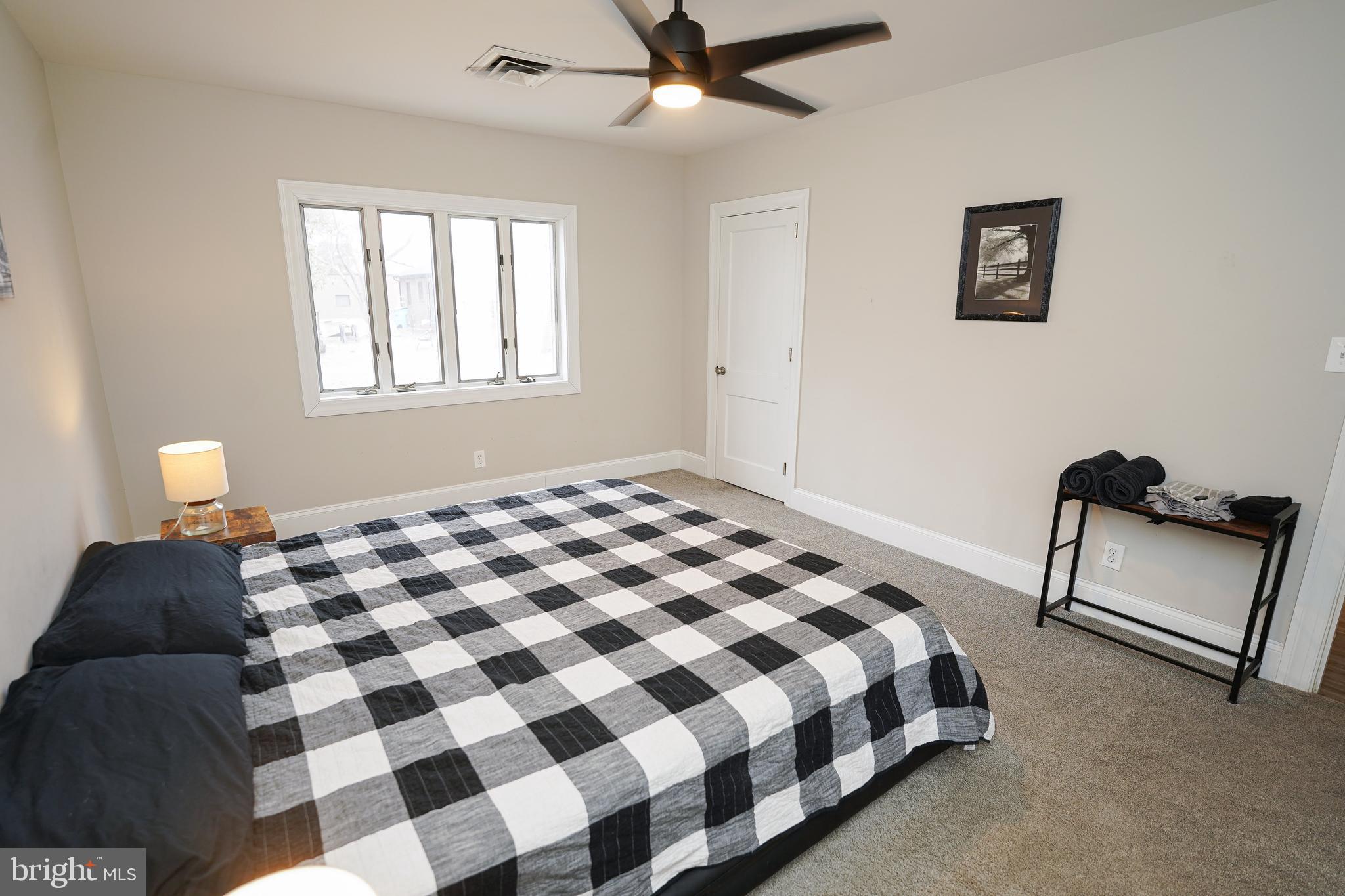 215 Pine Bluff Road Salisbury, MD 21801 - Photo 32 of 75 a bedroom with a bed and a lamp with a chandelier