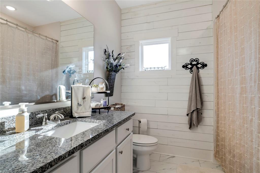 564 Old Airport Road Commerce, GA 30530 - Photo 23 of 39 a bathroom with a granite countertop sink a toilet and mirror